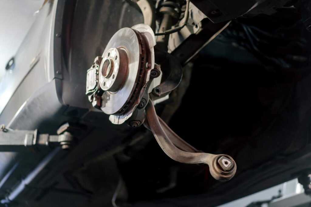 close-up of a rusty brake pad on a metal wheel holder at a service station