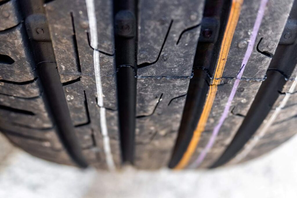 Detail of the grooves of a new car tire.