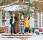 family dad and siblings teenage boy and girl near front door porch of village countryside house with swing hammock decorated for Christmas winter holidays, Christmas and New year vacation concept