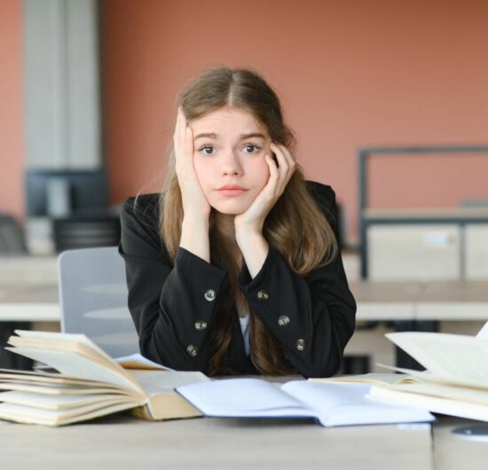 Lonely sad schoolgirl while all her classmates ignored her. Social exclusion problem. Bullying at school concept.