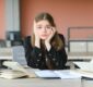 Lonely sad schoolgirl while all her classmates ignored her. Social exclusion problem. Bullying at school concept.