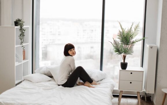 Caucasian woman resting at bedroom with panoramic windows
