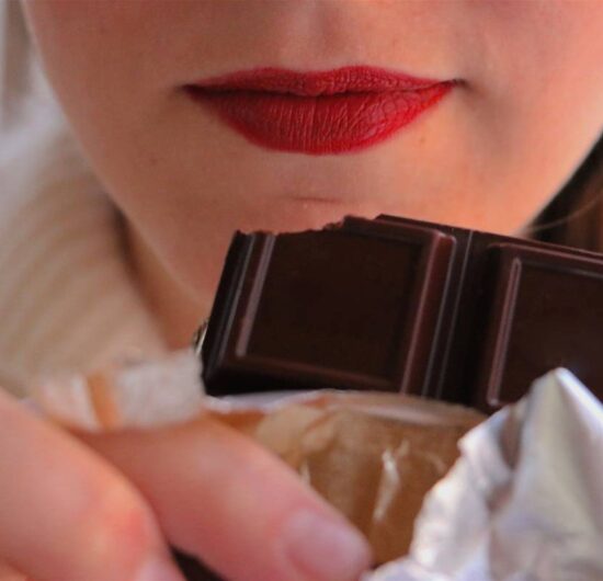 woman-with-red-lips-holding-chocolate-bar-close-to-2024-12-06-06-45-16-utc (1)