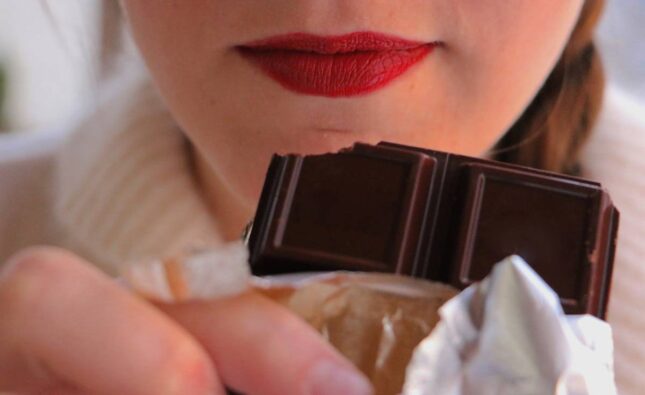 woman-with-red-lips-holding-chocolate-bar-close-to-2024-12-06-06-45-16-utc (1)