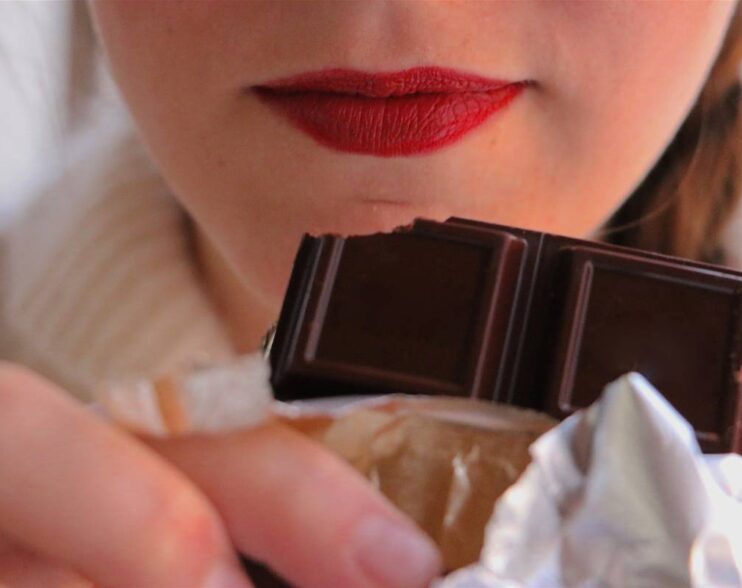 woman-with-red-lips-holding-chocolate-bar-close-to-2024-12-06-06-45-16-utc (1)