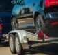 Used Cars Importing in European Union. Van Pulling Trailer with Damaged Pre Owned Vehicle For Sale in Other Country.